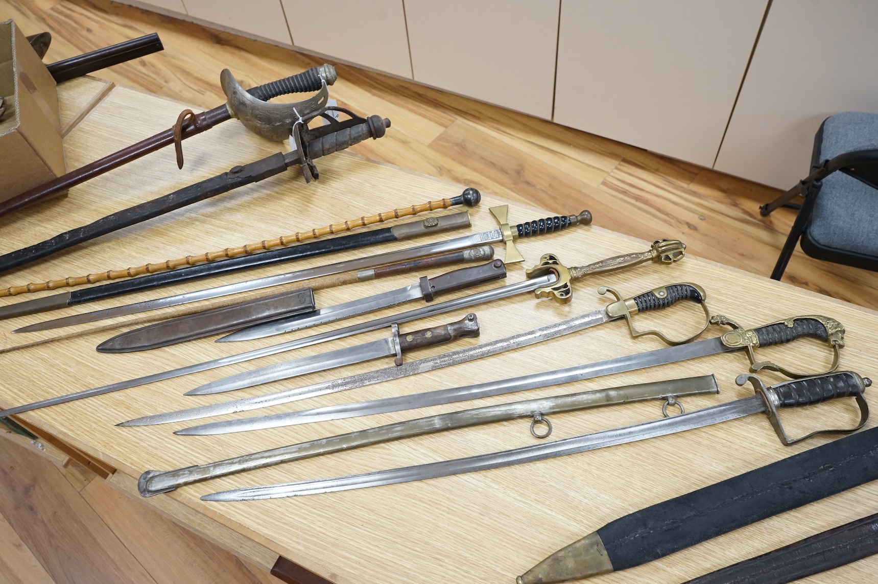 An Imperial German presentation infantry officer’s sword dated 1919/20, another similar with plain blade and brass stirrup hilt, another similar, plain in steel scabbard, a Wilkinson masonic sword probably circa 1950, a